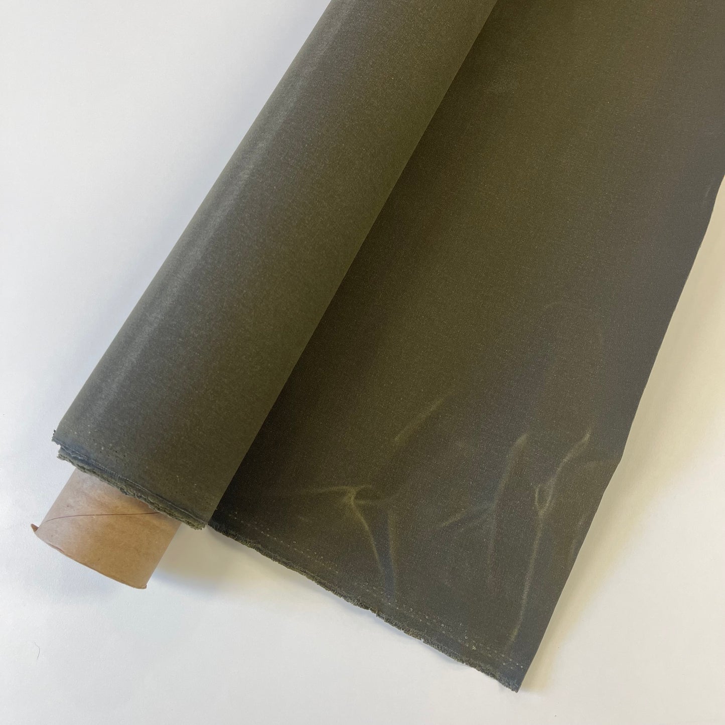 A close-up of a olive green waxed canvas fabric material for sewing and crafting and bag making.
