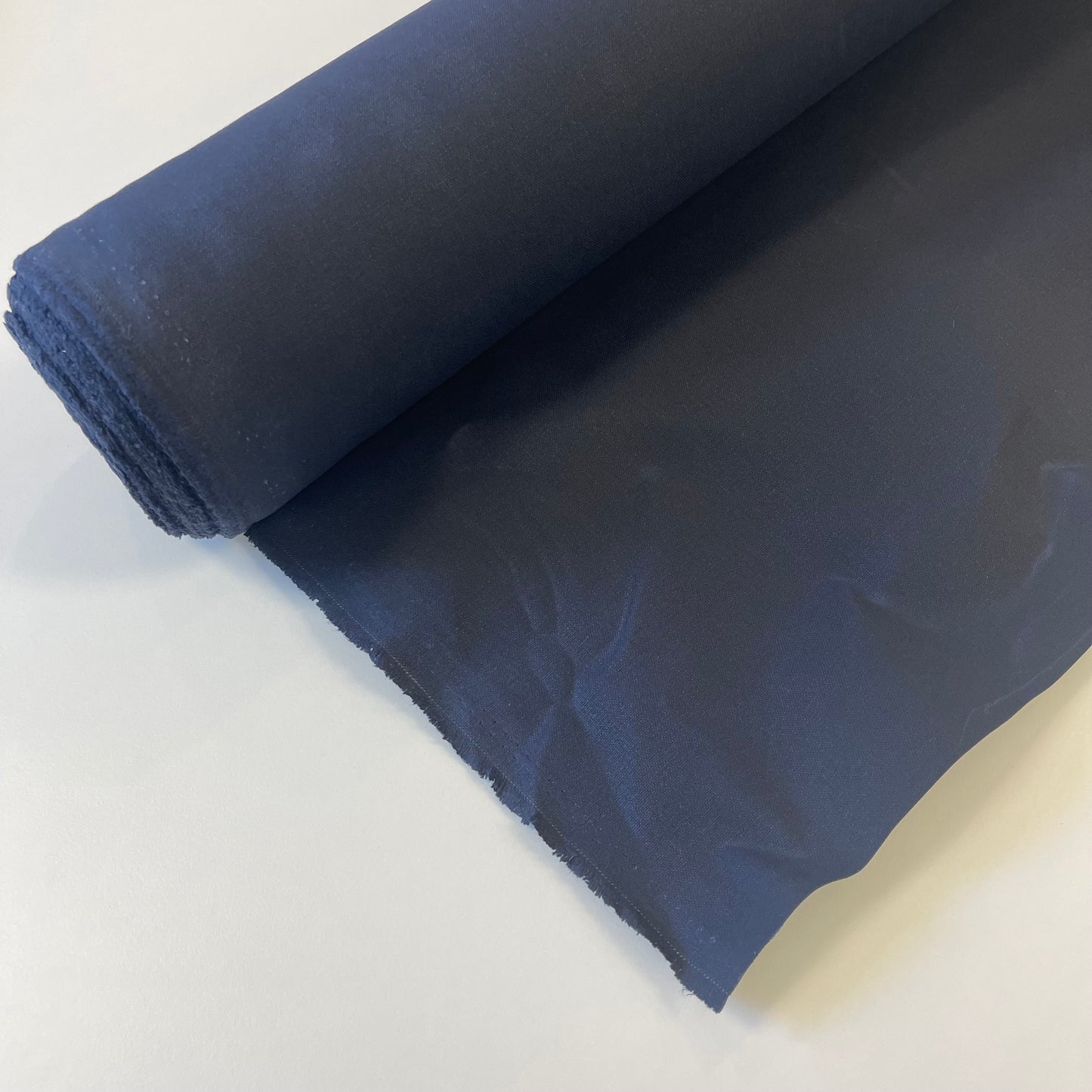A close-up of a navy waxed canvas fabric material for sewing and crafting and bag making.