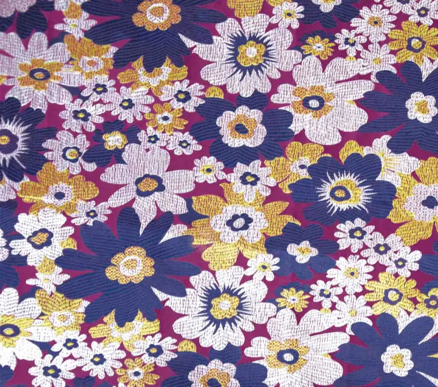 Colorful floral pattern brocade material with purple, yellow, and white flowers on a dark background