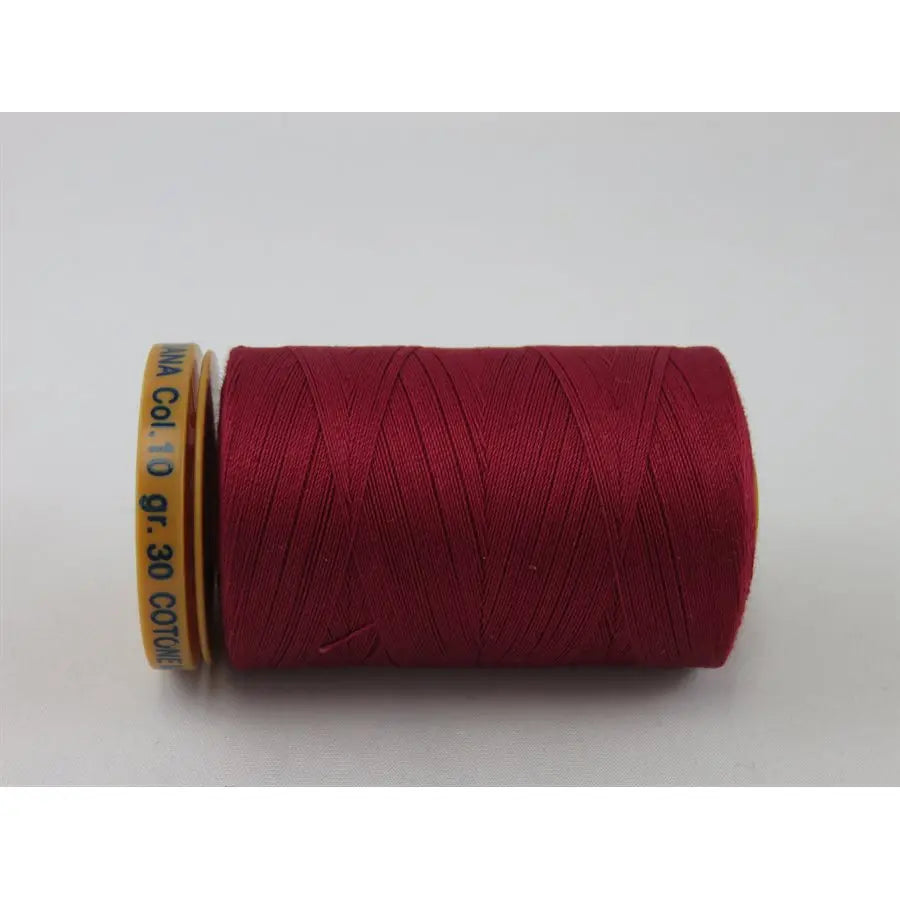A spool of 28 wt Genziana Italian cotton thread in a rosebud color.
