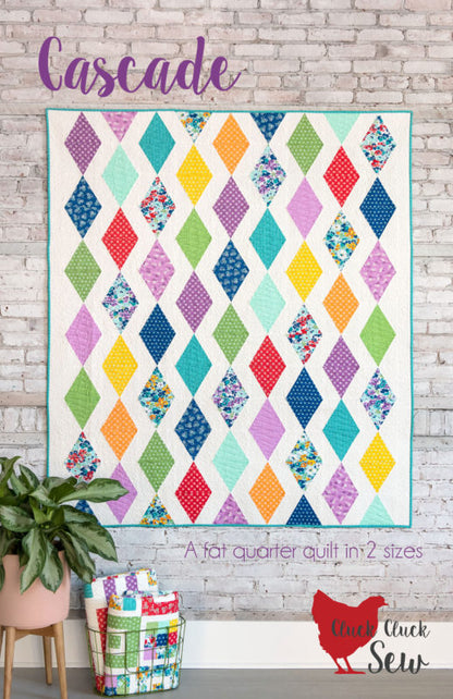 Colorful quilt pattern with diamond patterns on a brick wall.