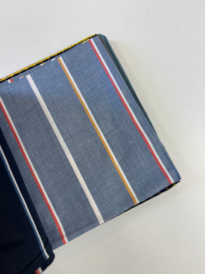 A folded piece of blue-gray striped fabric with vertical white, yellow, and red stripes, shown on a plain white background.