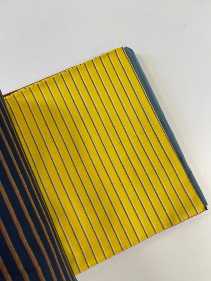 A close-up of a striped fabric or leather material sample with a bright yellow base and thin dark blue vertical stripes, shown on a plain white background.