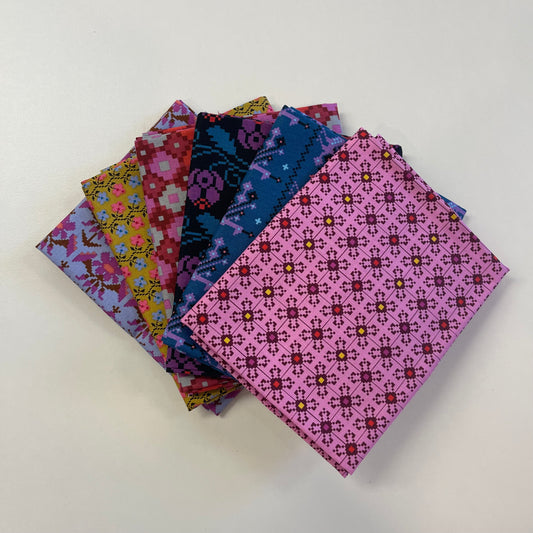 A stack of colorful patterned fabric squares fanned out on a plain white background. The fabrics feature various geometric and floral motifs in pink, blue, purple, yellow, and red.