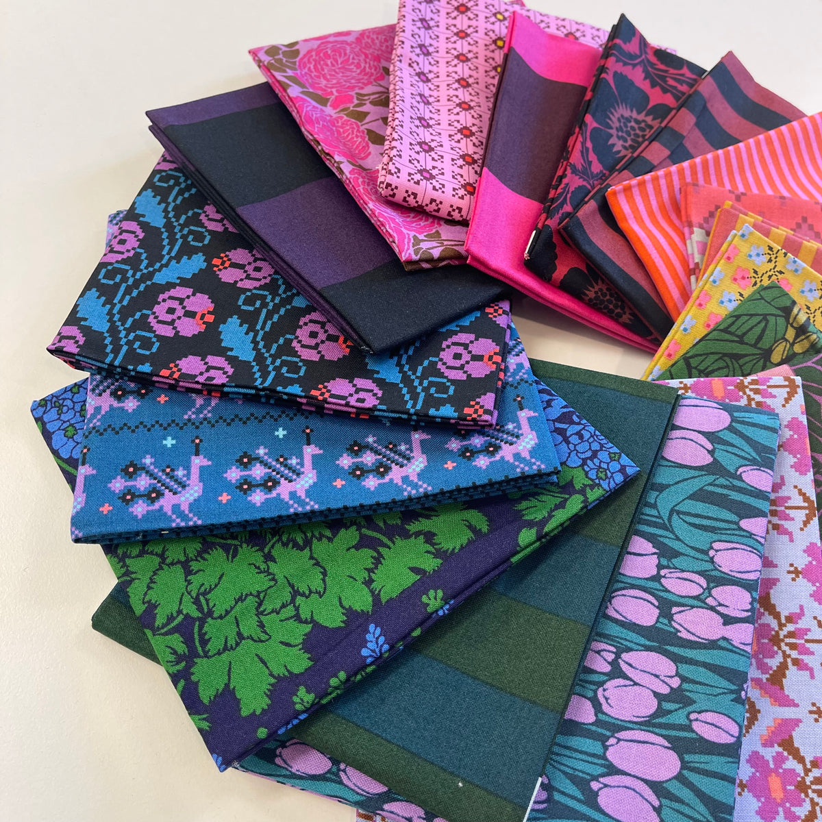 A pile of bold and vibrant fat quarter fabric pieces from Anna Maria Textiles for sewing and quilting. 