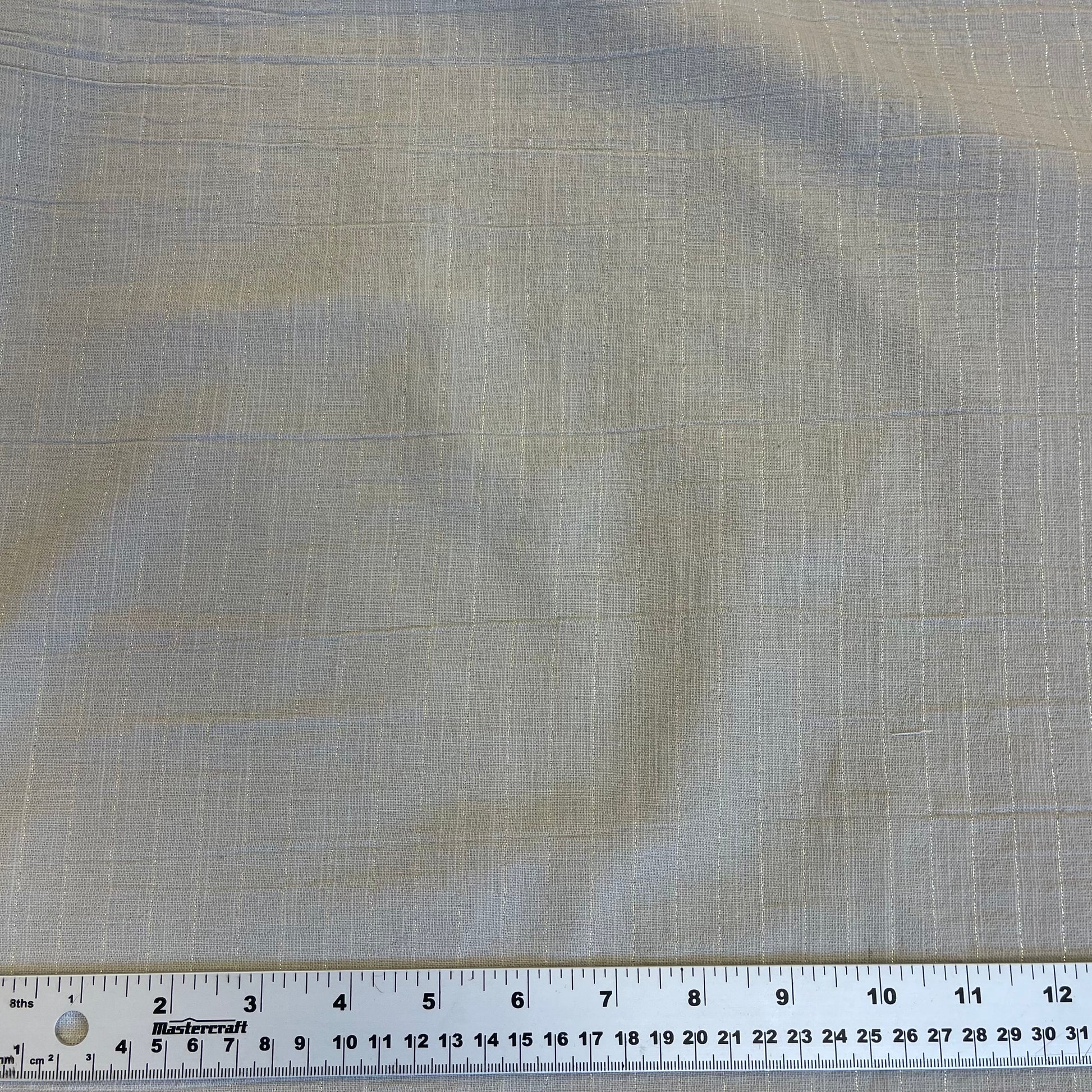 Textured cotton fabric with a ruler at the bottom for scale for sewing 