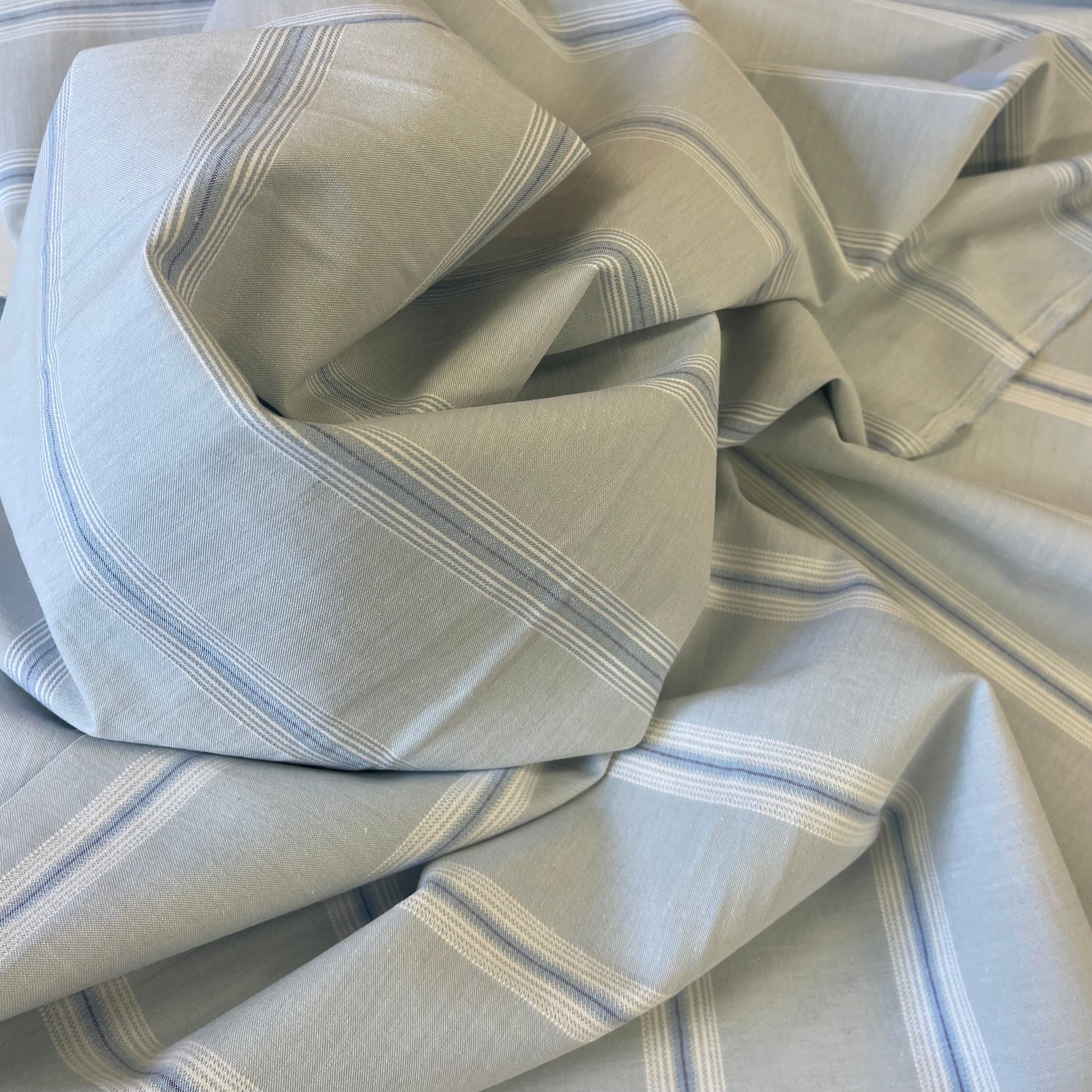 Folded cotton fabric with blue and white stripes for sewing garments