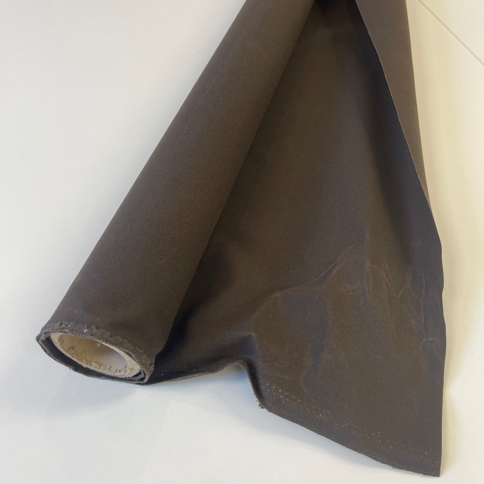 A close-up of dark brown waxed canvas fabric material for sewing and crafting and bag making.
