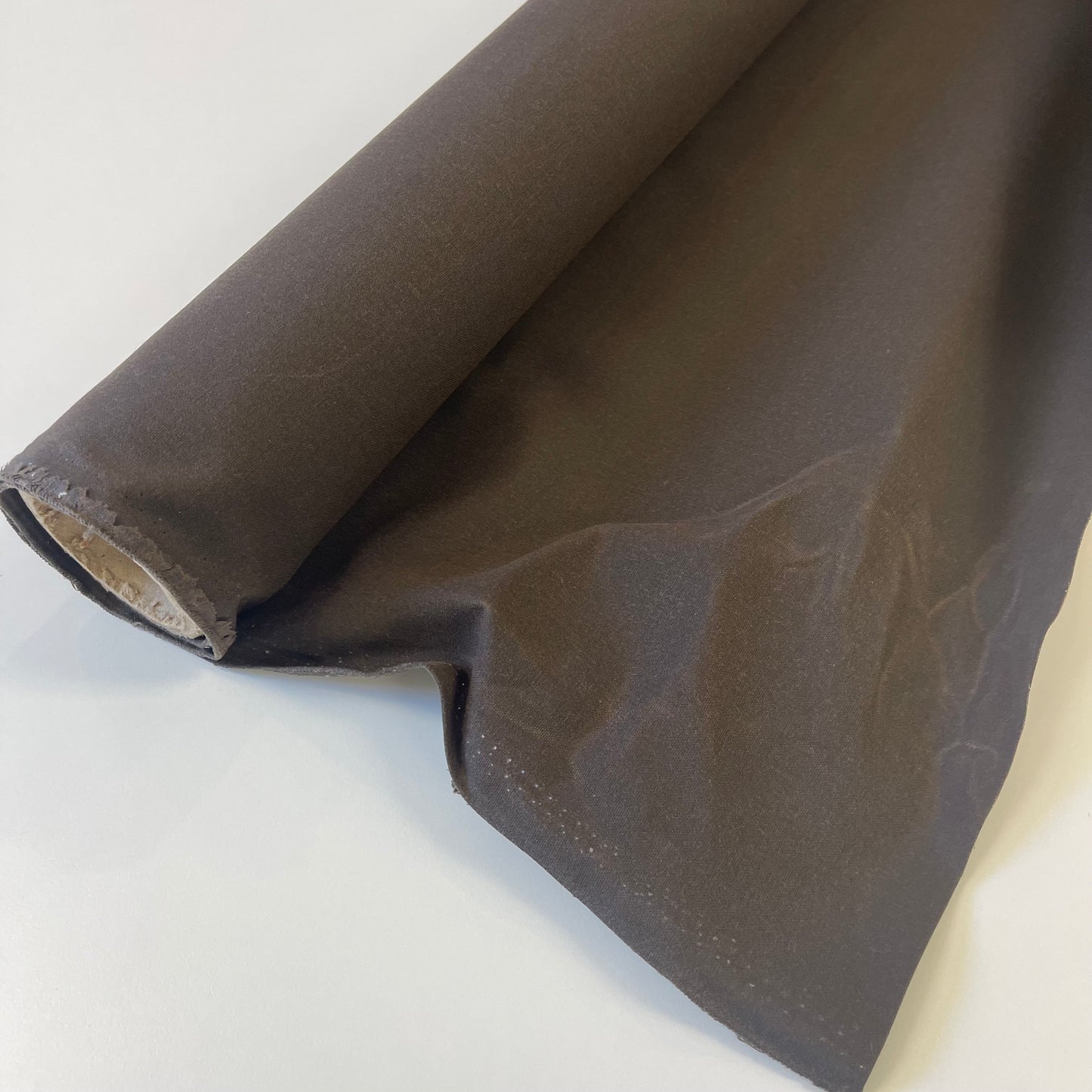 A close-up of dark brown waxed canvas fabric material for sewing and crafting and bag making.