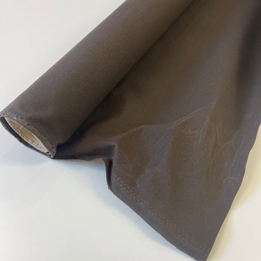 A close-up of dark brown waxed canvas fabric material for sewing and crafting and bag making.