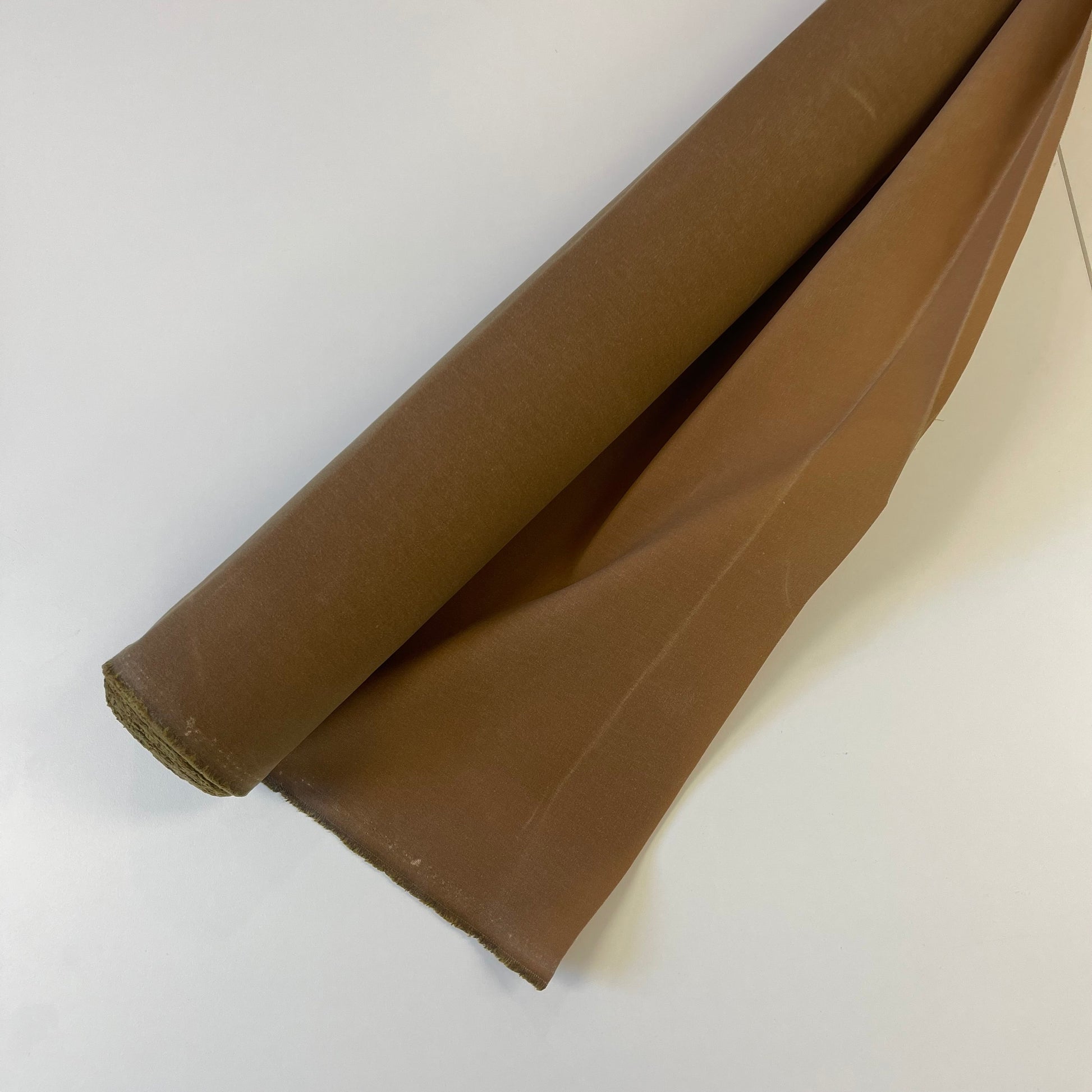 A close-up of a khaki brown waxed canvas fabric material for sewing and crafting and bag making.