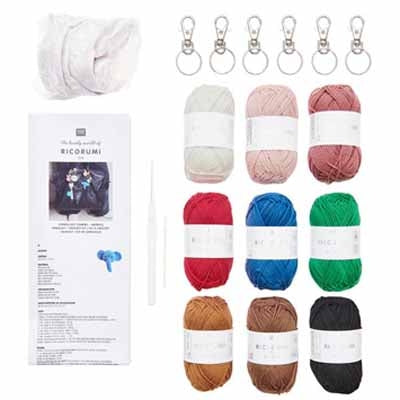 Set of yarn balls in various colors with keychains and a box on a white background
