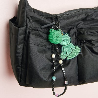 Black bag with a green decorative crochet on a black background