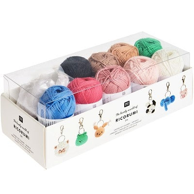 Box of colorful yarn balls with keychains on a white background