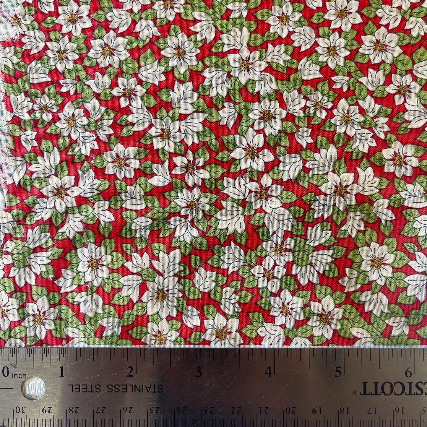 Fabric with white poinsettias on a red background from Liberty Fabrics for Christmas sewing, quilting, and crafting. 