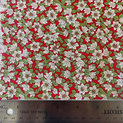 Fabric with white poinsettias on a red background from Liberty Fabrics for Christmas sewing, quilting, and crafting. 