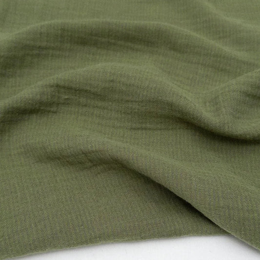 Close-up of green double gauze fabric with a textured striped pattern