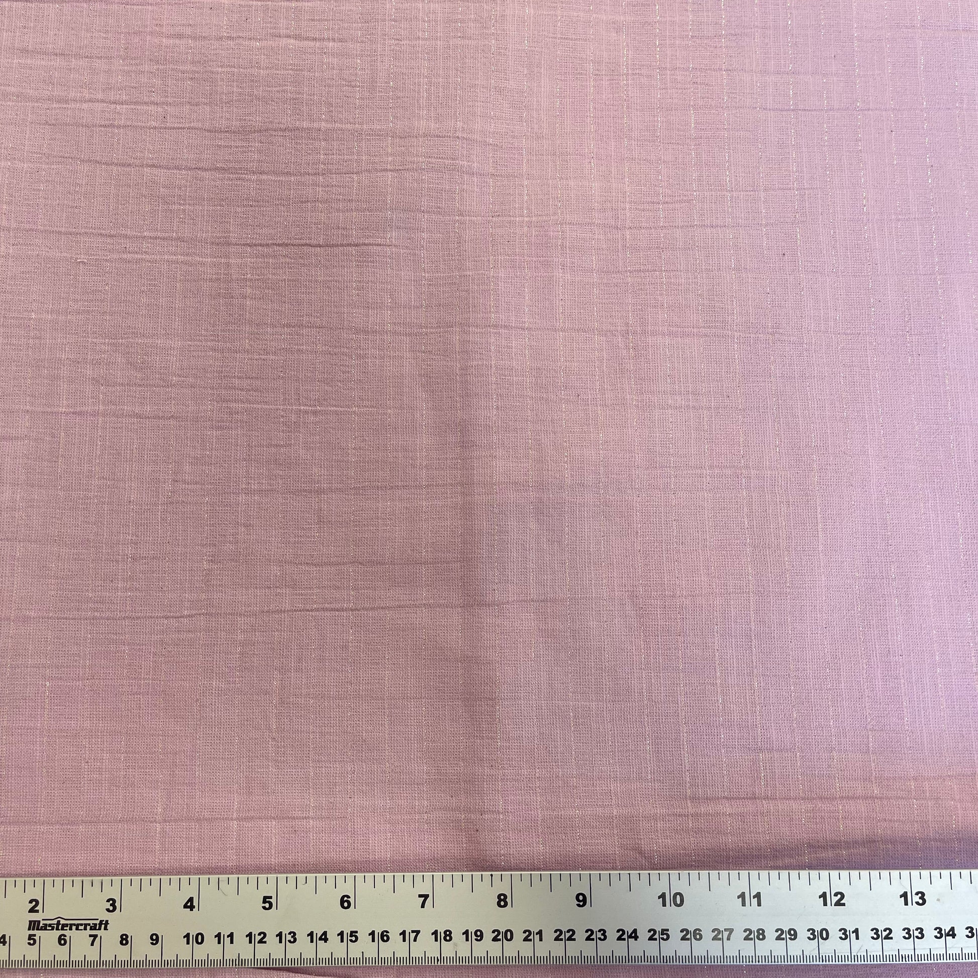 Textured cotton lightweight fabric swatch with a ruler at the bottom for scale