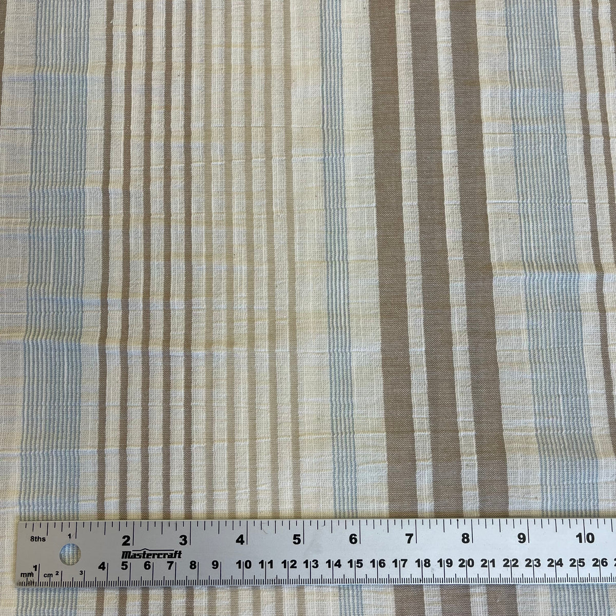 Textured fabric with stripes and a ruler at the bottom for scale.