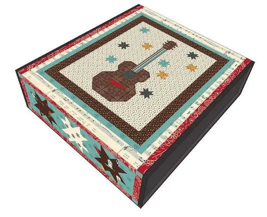 A quilt kit box with a country song theme, featuring a variety of fabric patterns including a guitar and musical notes.