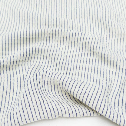 Close-up of white cotton organic fabric with blue stripes for sewing and crafting. 