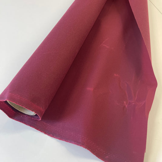 A close-up of dark red waxed canvas fabric material for sewing and crafting and bag making.