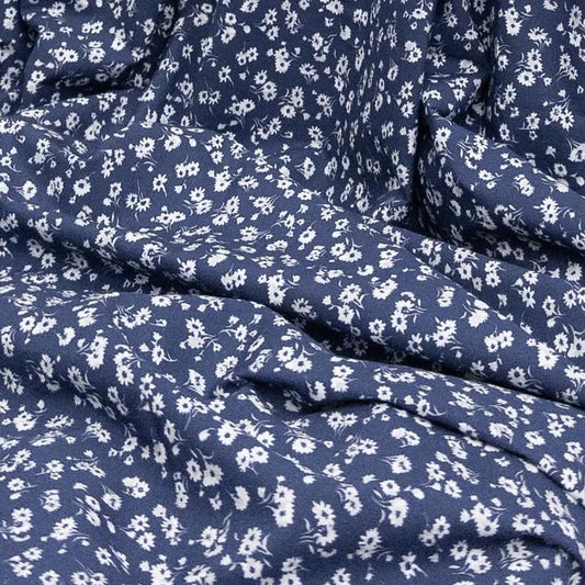 Blue organic cotton fabric with small white floral pattern for sewing and crafting