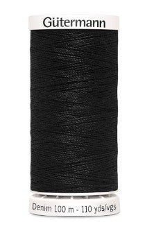 Spool of black Gütermann denim thread on a white background