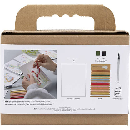 Cardboard box packaging for a craft kit with images of hands working on a embroidery project and materials listed.