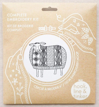 Embroidery kit packaging with a sheep illustration on a beige background