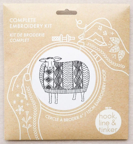 Embroidery kit packaging with a sheep illustration on a beige background