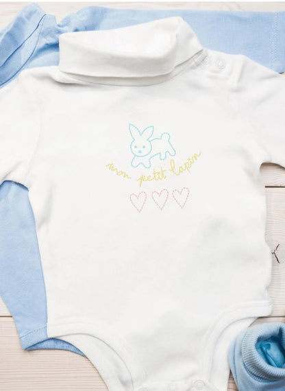 White baby bodysuit with embroidery designs. 
