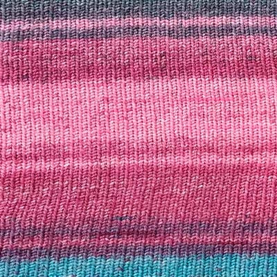 close up of sock yarn for knitting and crafting in a gradient berry color