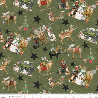 Christmas-themed fabric with animals and stars on a green background, ruler at the bottom.