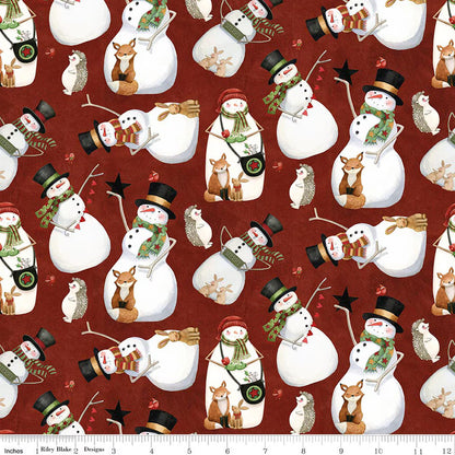 Pattern of snowmen and animals on a red background with a ruler for scale.
