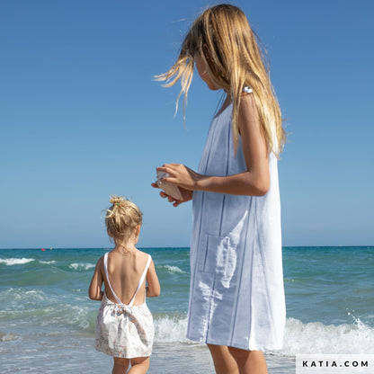 Two children at the beach in blue striped cotton fabric