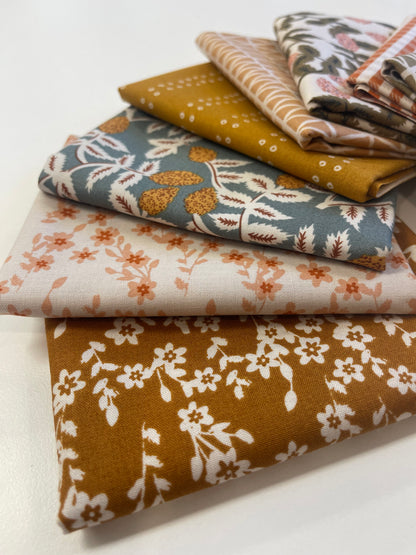 Collection of folded fabric swatches with various patterns on a light background
