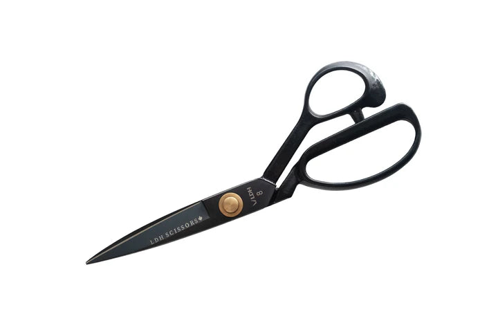 Black scissors with gold accents on a white background