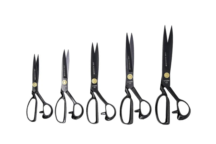 Set of six pairs of black-handled fabric shears scissors on a white background