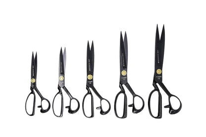 Set of six pairs of black-handled fabric shears scissors on a white background