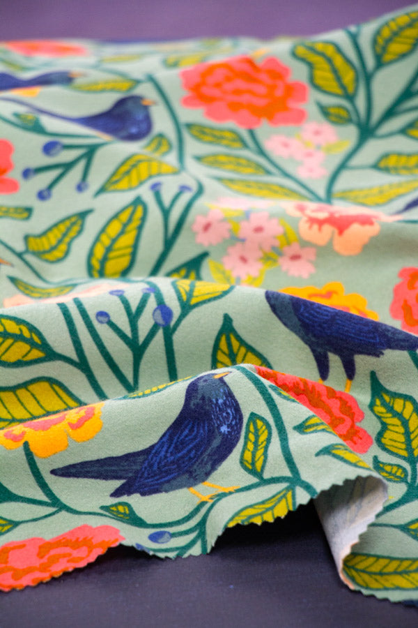 Floral fabric with birds and colorful flowers on a dark background