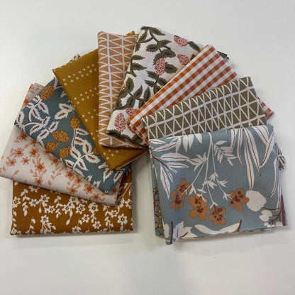Collection of patterned fabric swatches on a white background for sewing and quilting. 