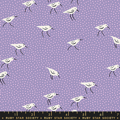 A repeating fabric pattern featuring white sandpipers with black beaks and legs on a light purple background with small white polka dots. A black measurement scale bar with 'RUBY STAR SOCIETY' text is visible along the bottom edge.