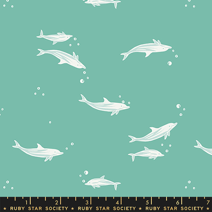 A repeating pattern of white dolphins swimming on a teal background, with a black ruler strip along the bottom edge labeled Ruby Star Society.
