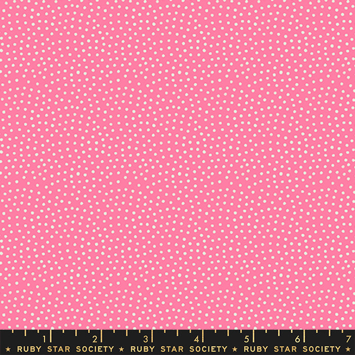 Pink fabric with a repeating pattern of small white dots, shown flat with a Ruby Star Society ruler along the bottom edge for scale.
