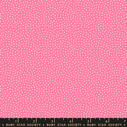 Pink fabric with a repeating pattern of small white dots, shown flat with a Ruby Star Society ruler along the bottom edge for scale.