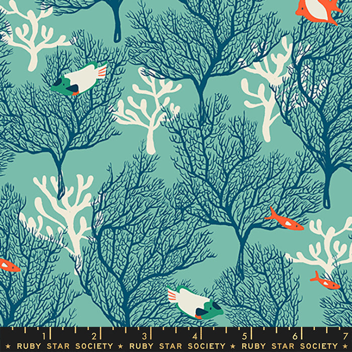 A repeating fabric or wallpaper pattern featuring dark blue coral trees on a teal background, with white coral structures, small orange fish, and white birds with green and orange accents. A black ruler strip at the bottom shows measurements and repeats the brand name Ruby Star Society.