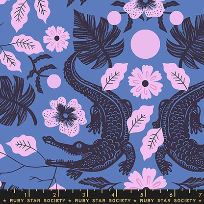 A repeating fabric pattern featuring dark navy blue alligators, pink hibiscus flowers, and pink leaves on a periwinkle blue background, with a Ruby Star Society ruler printed along the bottom edge.