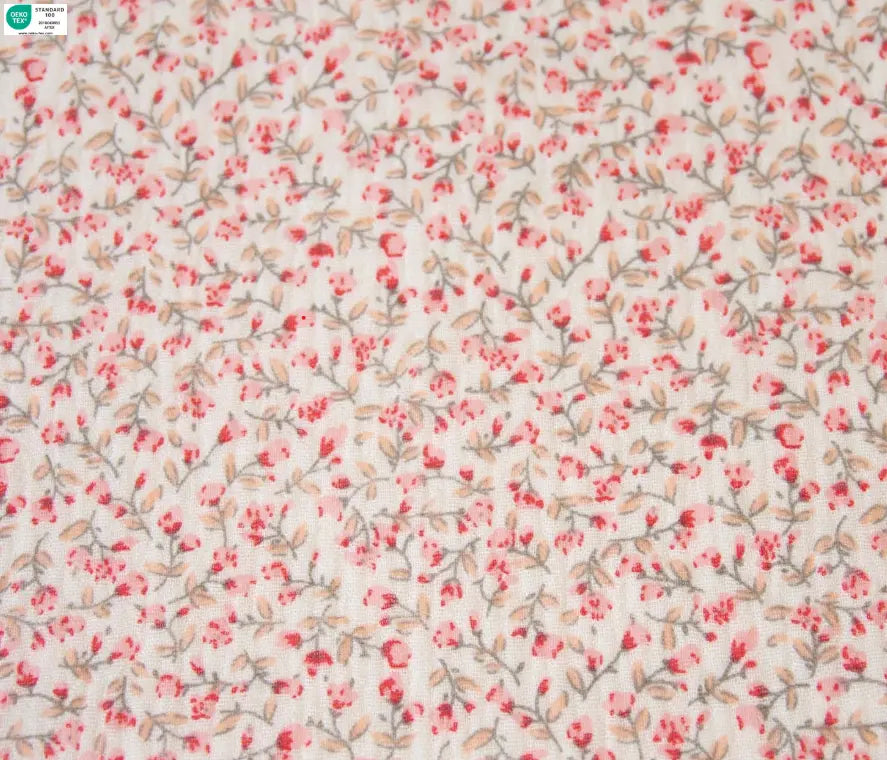 Floral patterned fabric with small pink flowers and green leaves on a light background cotton fabric for sewing.
