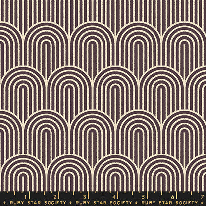 A repeating fabric pattern featuring cream-colored arches and vertical lines on a dark brown background, with a black ruler at the bottom showing the Ruby Star Society brand and scale markings.